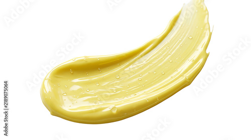 A yellow cosmetic cream texture is smeared against a white background