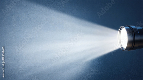 Flashlight beam shining on textured wall with bright focused light