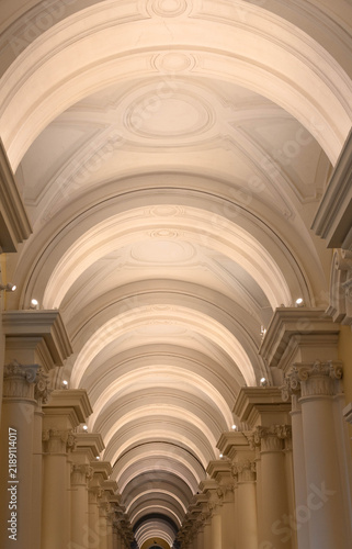 Symmetrical white arched ceiling with columns in a classical building
