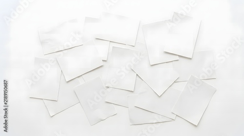 Abstract white paper shapes scattered on a light gray background with soft shadows