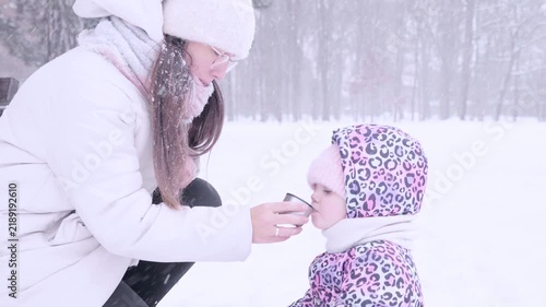 Child winter tea. Toddler drinking warm beverage outdoors. Parental care concept.