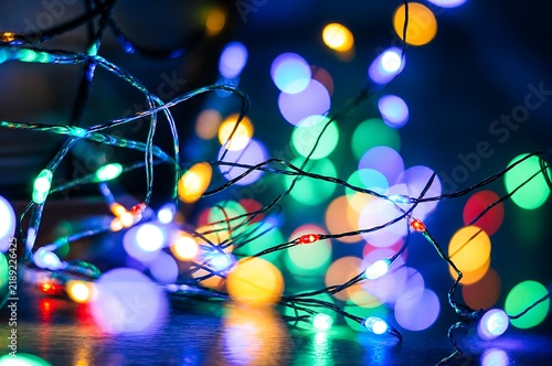 Tangled colorful LED fairy lights glowing with soft bokeh background on dark surface