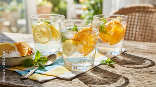 Refreshing citrus drinks with mint and ice on a sunny table setting