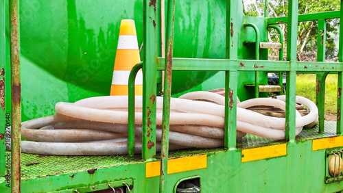 Green Truck Bed with Hose and Cone: A close-up of a green truck bed reveals a coiled hose and a traffic cone, hinting at industrial or maintenance work.