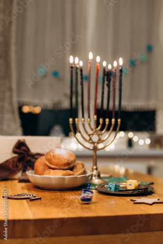 Quadro su tela Celebrating hanukkah with lit menorah and traditional sufganiyot