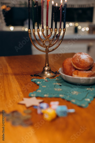 Fotografie Hanukkah celebration with lit menorah and traditional sufganiyot