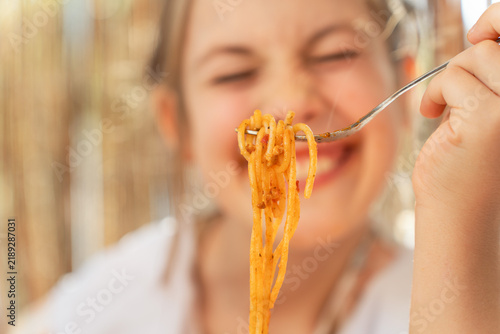 Konstfotografi Young girl eating spaghetti, representing childhood, family mealtime and children’s food in an everyday lifestyle setting