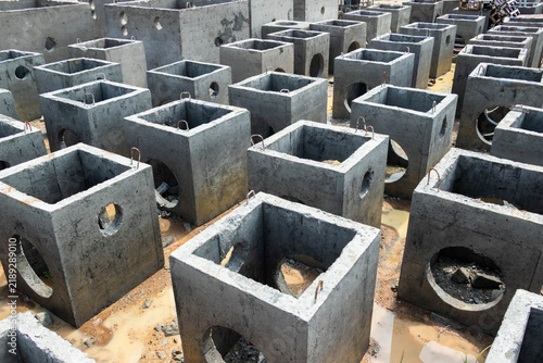 Fotografie Multiple square concrete drainage chambers arranged in organized rows awaiting i
