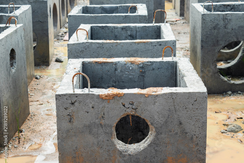 Fotografie Multiple square concrete drainage chambers arranged in organized rows awaiting i