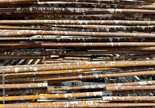 Fotografie Close-up of rusty reinforcing steel bars with concrete splatters in a construction site