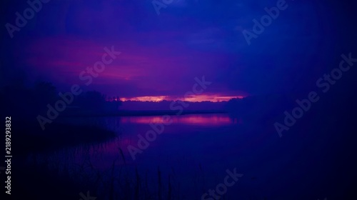 Mist veils a calm lake under twilight's deep hues