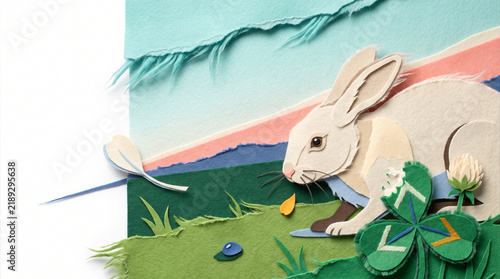 Rabbit nibbling on clover in a colorful paper landscape  
