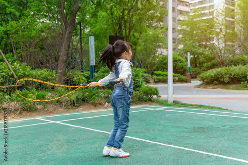 Konstfotografi Happy Asian girl skipping rope outdoors in park, active child exercising and hea