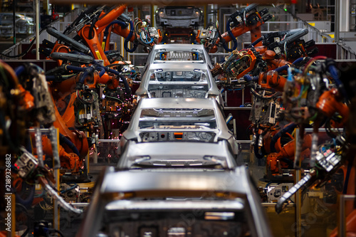 Automated production line for the automotive industry; intelligent factory robotic arms in a vehicle manufacturing workshop.