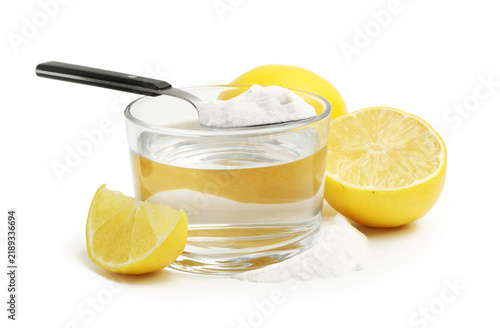 Fotografía Baking soda in spoon, glass of water and lemons isolated on white