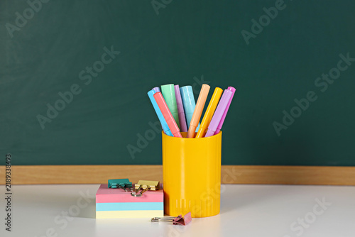 Stationery on white table against chalkboard. Space for text