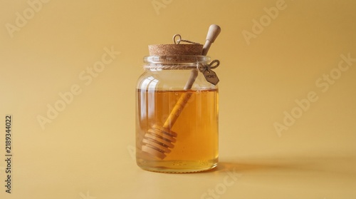 Pure natural honey jar mockup with wooden dipper wand on warm amber backdrop for organic food, breakfast, and healthy sweetening concept