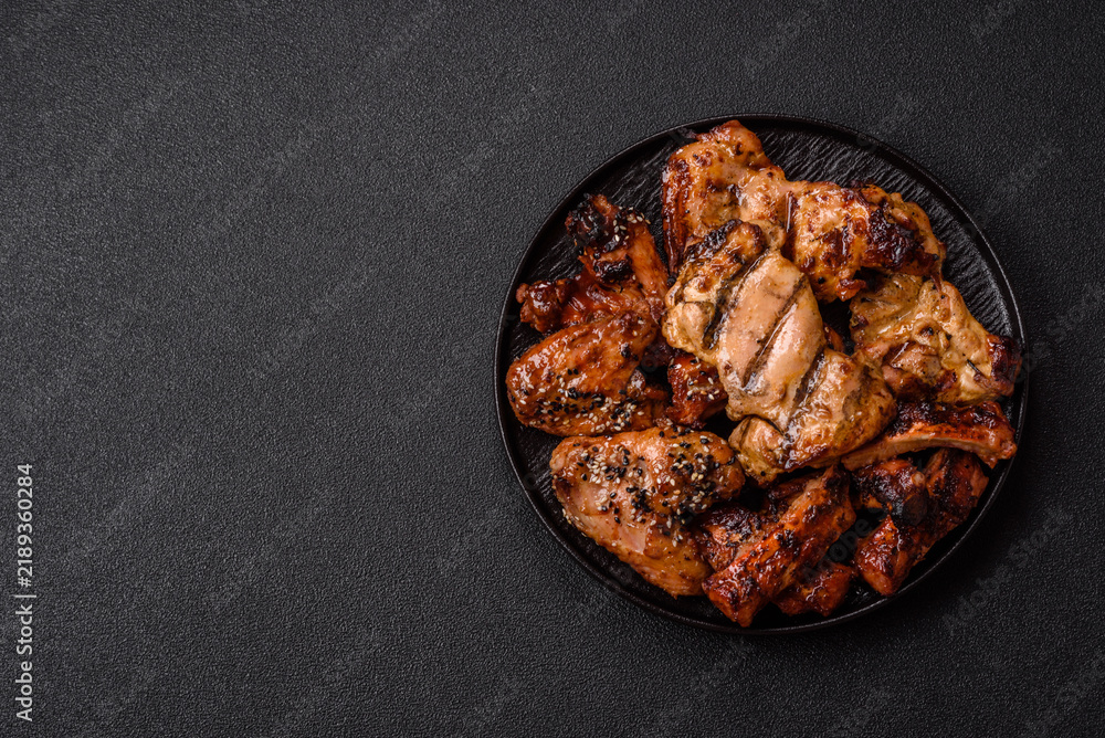 Obraz premium Grilled meat set featuring chicken breast, wings, and ribs seasoned with spices. Grilled meat set