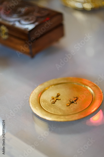Konstfotografi Two golden crosses lie on a metal plate, prepared as baptismal crosses for a Christian church ceremony