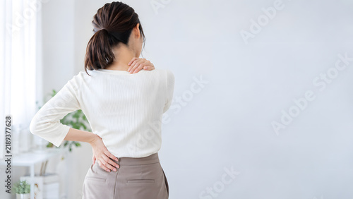 Naklejka 肩こりと腰痛に悩む日本人女性の後ろ姿