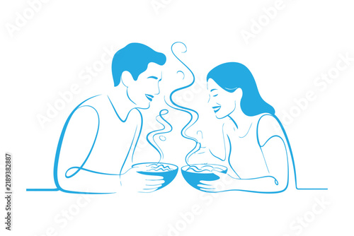 Happy young couple enjoying a warm bowl of soup together in a cozy casual setting
