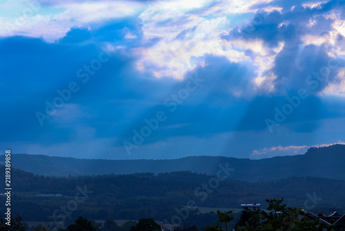 Photography Sunbeams through clouds over a valley