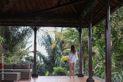 Woman in a Short White Tunic Standing on a Terrace Surrounded by Jungle