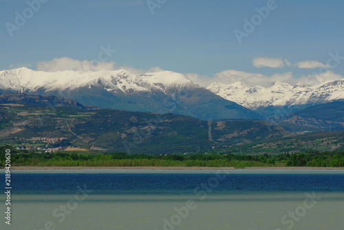 Cumulus clouds over the snow-capped peaks of the Pyrenees, with the Tremp reservoir in the foreground.