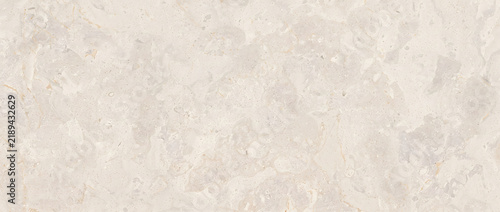 Beige limestone texture with cloudy grey patches and speckled mineral grain forming a soft natural background for interior design