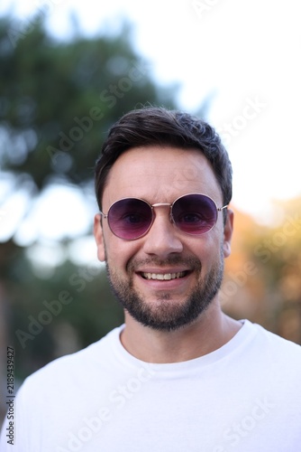 Handsome man wearing stylish sunglasses on city street
