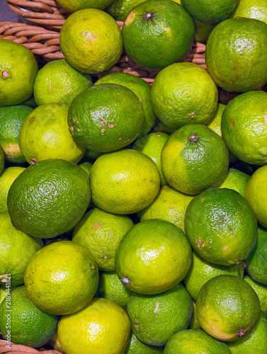 Obraz na plátne Yellow green limes offered on a food store counter, presenting fresh citrus prod