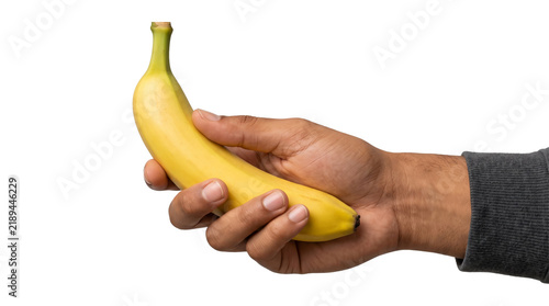Foto Hand grasping an upright ripe yellow banana firmly showing its green stem tip po