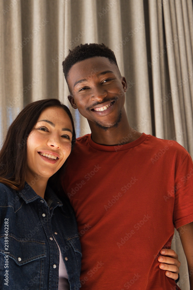 Obraz premium Diverse couple standing and leaning in studio before curtain, denim jacket and rust shirt
