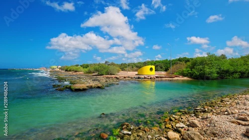 Beautiful view of coastal lagoon opening into Caribbean Sea with rocky shoreline and waves. Curacao.