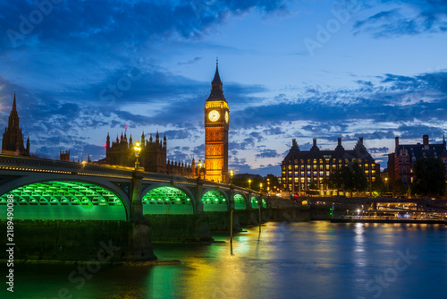 Night view of the Houses of Parliament and Big Ben along the Thames River in London, England.