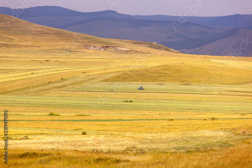Vast rolling hills under a dramatic sky with agricultural fields below