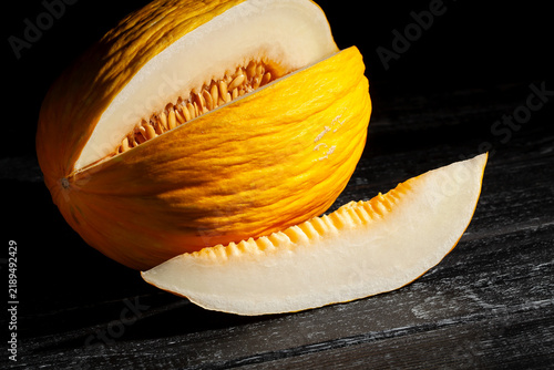 Obraz na plátně sliced casaba melon on black wood background