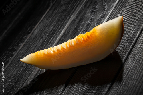Fotografie sliced casaba melon on black wood background