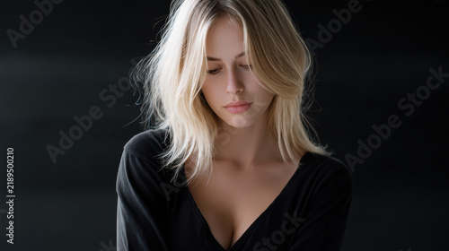 Blond woman black shirt medium length hair soft light studio pensive beauty natural makeup serene mood