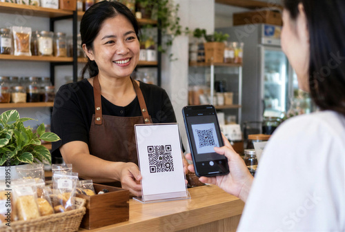 Customer Scanning QR Code via Smartphone at Coffee Shop Checkout Counter