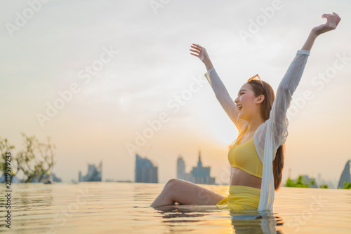 Konstfotografi Joyful woman raising arms in rooftop pool at sunset, embracing liberation, golden hour serenity, mindful breathing, wellness rejuvenation, spiritual peace, boundless freedom, and pure travel bliss