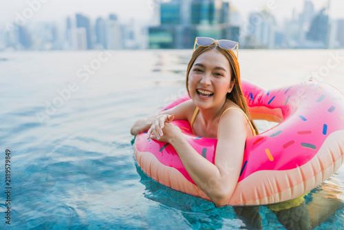 Canvastavla Euphoric woman floating on pink inflatable donut in swimming pool, laughing with open arms, embracing summertime playfulness, carefree cheerfulness, tropical getaway bliss, and pure active joy