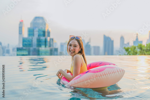 Canvastavla Euphoric woman floating on pink inflatable donut in swimming pool, laughing with open arms, embracing summertime playfulness, carefree cheerfulness, tropical getaway bliss, and pure active joy