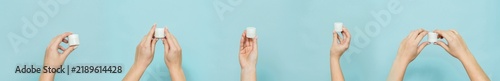 Hands holding white cosmetic jars against blue background