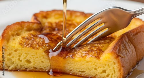 A vivid, atmospheric reinterpretation of close-up of fork cutting into fluffy French toast with syrup stretching, shallow depth of field, photorealistic detail, written with richer detail and modern c
