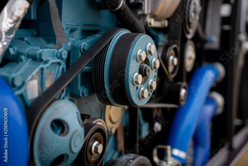 Close-up view of engine drive belt, pulleys, and blue block components on a modern industrial machine.