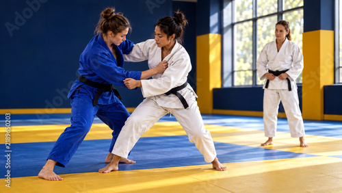 Female Judo Athletes Practicing Grappling Techniques in Dojo