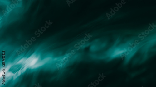 Cinematic grainy texture background with dark teal and emerald green light le...