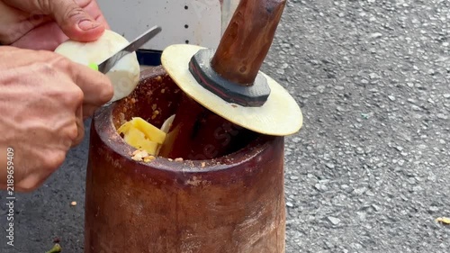Making rujak bebek, Indonesian food made of mix fruits with chili, salt, and palm sugar grinded together using traditional grinder made of wood