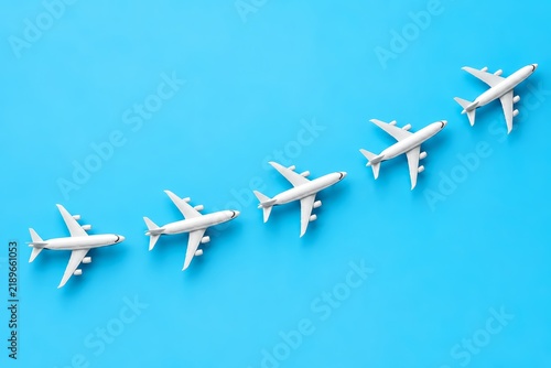 Small white planes fly in a chain across a bright blue background representing new tourist destinations.